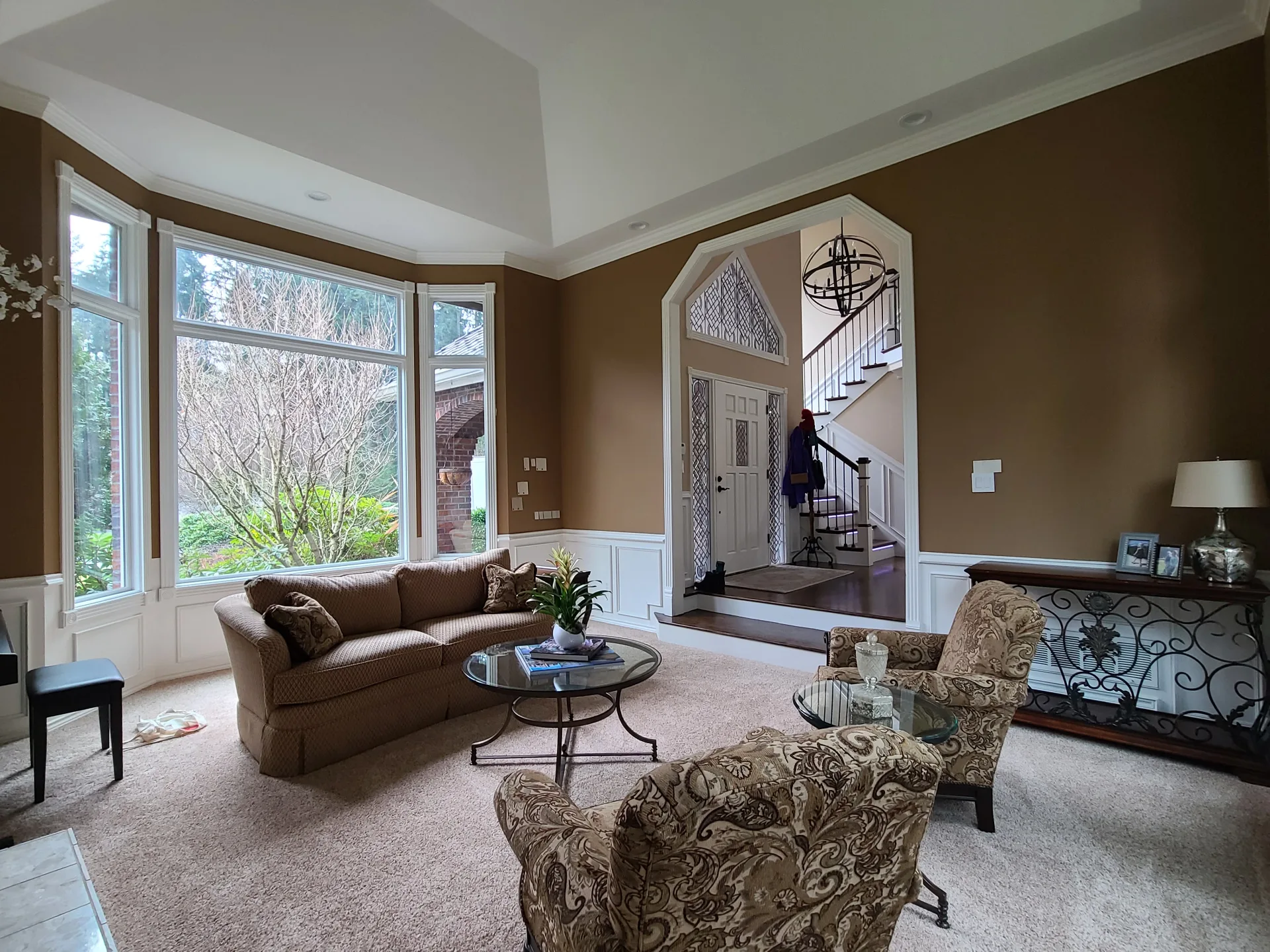 Elegant living room with warm brown walls and white wainscoting